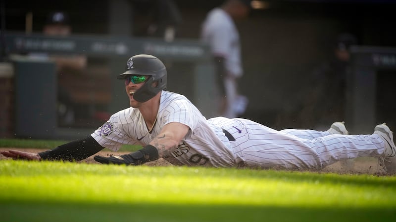 Colorado Rockies' Brenton Doyle reacts after scoring the winning run on a wild pitch by...
