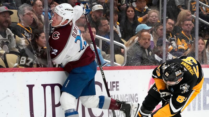 Colorado Avalanche's Fredrik Olofsson (22) crashes into the boards after colliding with...