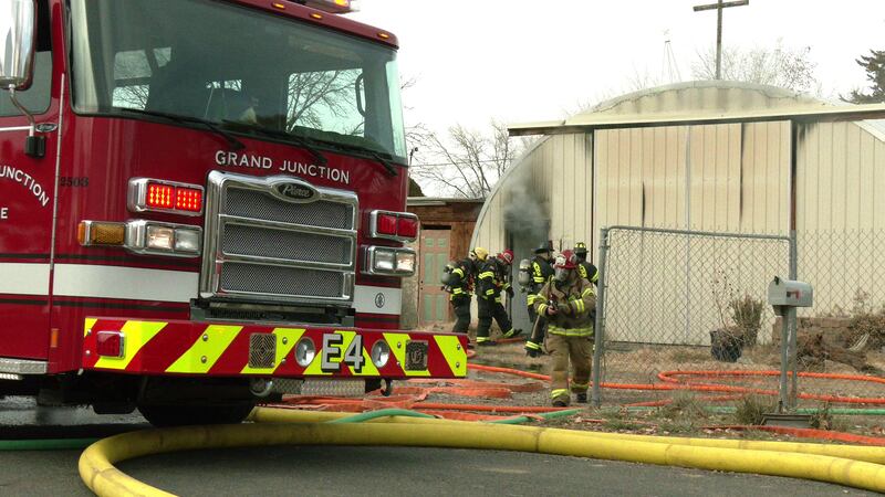 Firefighters work to contain a blaze inside a Quonset-style building