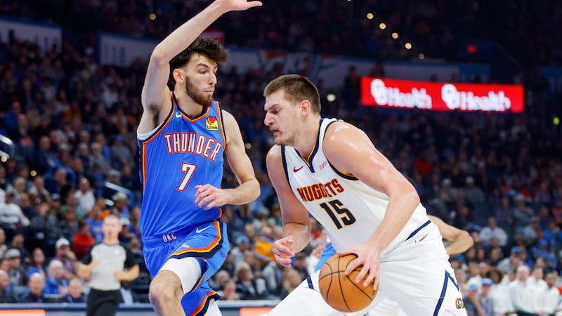 Denver Nuggets center Nikola Jokic (15) drives against Oklahoma City Thunder forward Chet...