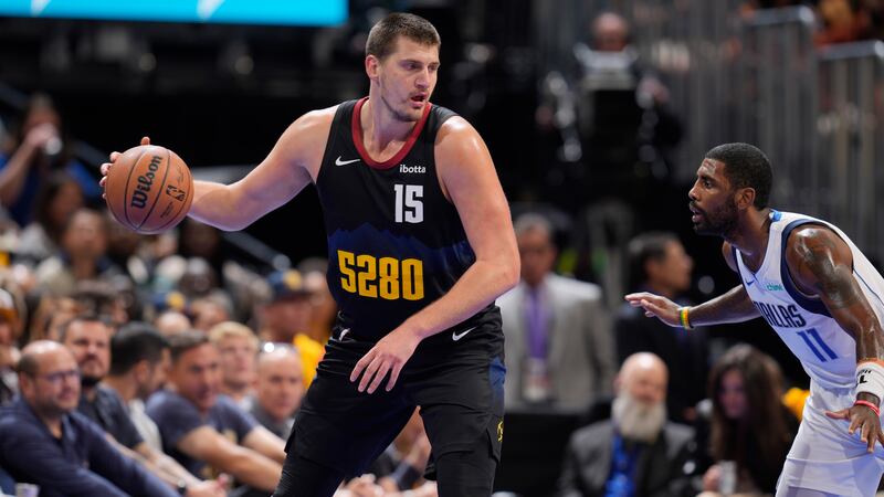 Denver Nuggets center Nikola Jokic, left, is defended by Dallas Mavericks guard Kyrie Irving...